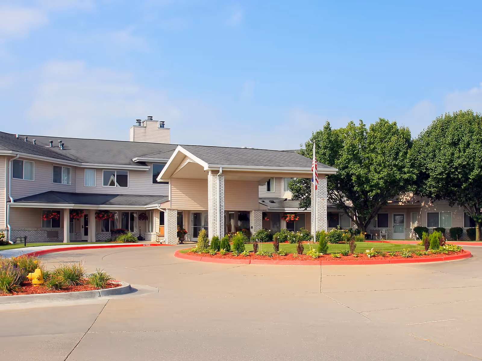 Exterior view of Holiday Illahee Hills senior living facility with a circular driveway.