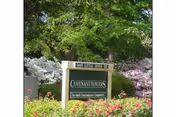 A landscaped entrance sign reading "Covenant Towers" surrounded by flowering shrubs and trees.