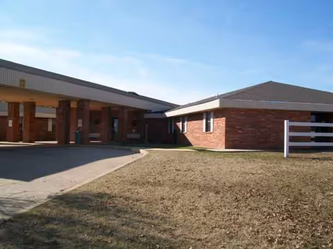 Exterior view of a brick senior living center with a covered entryway.