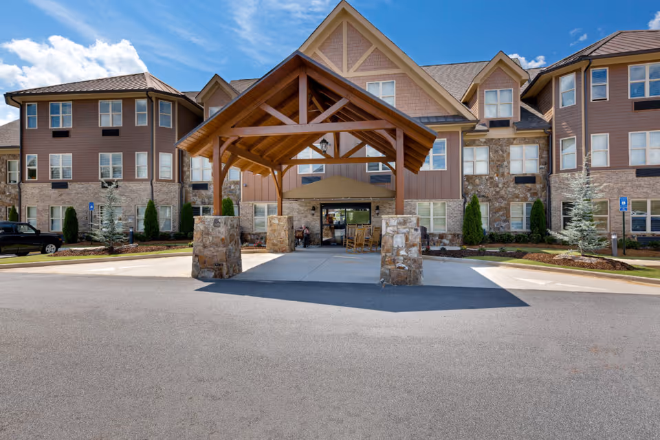 Exterior view of Oaks at Acworth senior living with stone entry canopy and driveway.