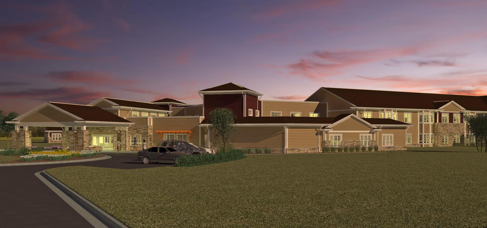 Exterior view of Oak Park Place Green Bay facility at dusk, showing a large building with multiple windows, a covered entrance, parked cars, and a few people walking near the entrance. The sky is colorful with shades of purple and pink.