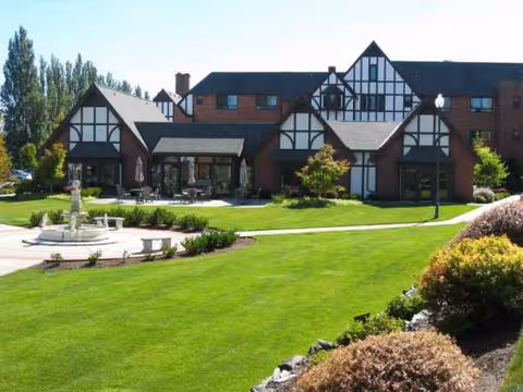 Front exterior view of Franke Tobey Jones senior living campus with green lawn and fountain