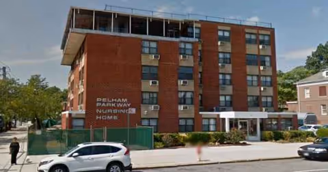 Exterior view of a brick nursing home building along a city street.