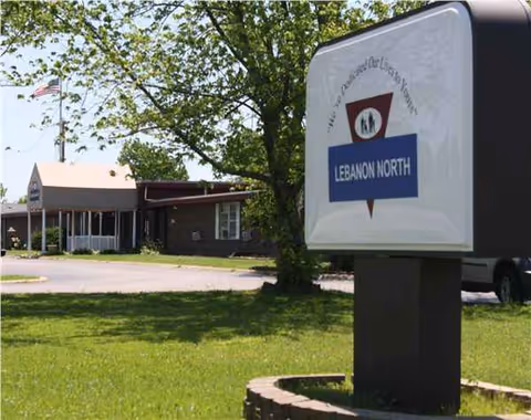 Outdoor scene with Lebanon North sign foreground and facility building visible behind.