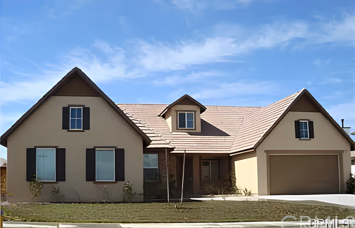 Front exterior of a single-story beige house with a pitched roof, two-car garage, and small front yard.