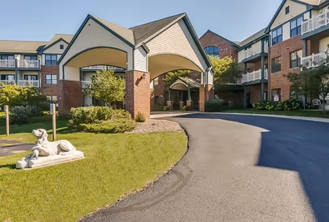 Exterior view of Meadowmere & Mitchell Manor Oak Creek with curved driveway and entrance canopies.
