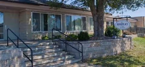 Front view of Homeplace of Mondovi facility with steps, railing, and sign.