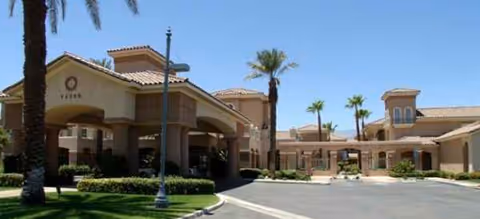 Front exterior view of Brookdale Mirage Inn with palm trees and a covered entrance.