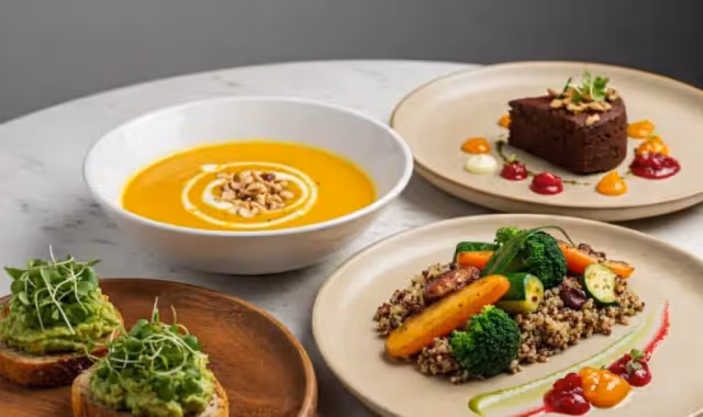 Assorted plated meals including soup, vegetables, and dessert on a marble table.