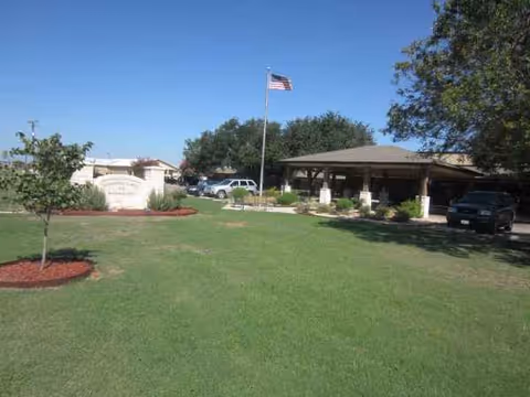 Front exterior view of Silver Pines Nursing and Rehabilitation Center with flag, lawn, and entrance.
