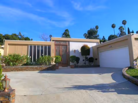 Front exterior of Laurelwood Villa facility, showing driveway, shrubs, and a two-car garage.