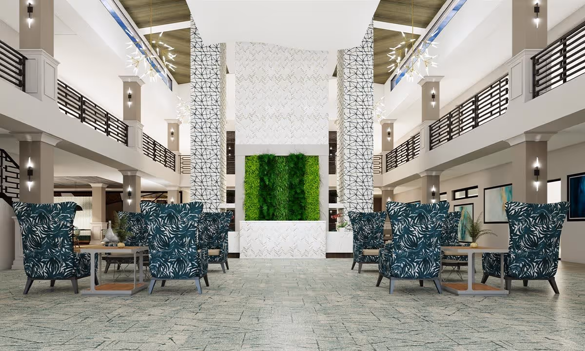 A spacious lobby interior featuring modern decor, large green plants, and comfortable seating arrangements with patterned chairs.