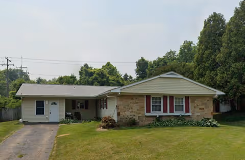Single-story senior living facility with a brick facade and a driveway to a covered entrance.