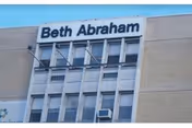 Exterior view of a multi-story building with a sign reading 'Beth Abraham' at the top.