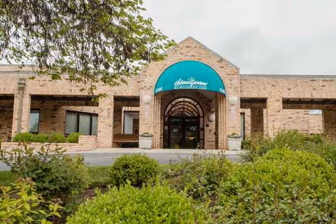 Delmar Gardens of Overland Park exterior with teal entrance awning and manicured landscaping.