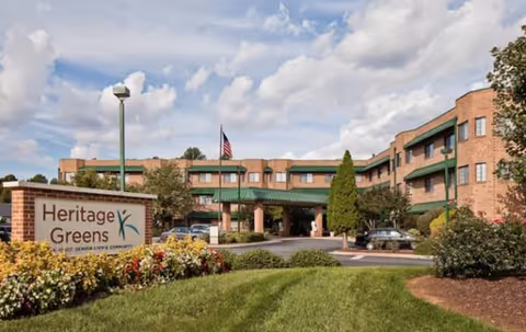 Heritage Greens senior living building exterior with landscaped entry and sign.