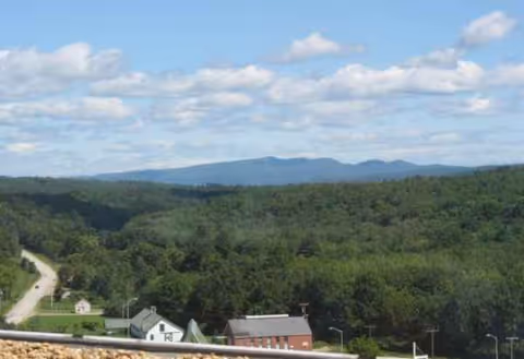 Scenic outdoor view from Merrimack County Nursing Home overlooking trees and hills.