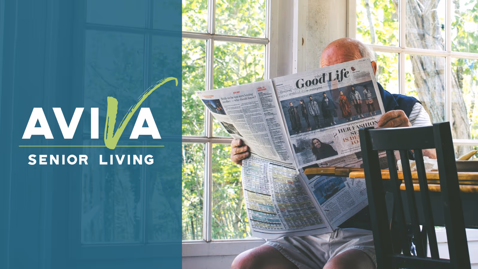 An elderly man sitting indoors near large windows, reading a newspaper titled 'Good Life'. The background shows green trees outside the window.