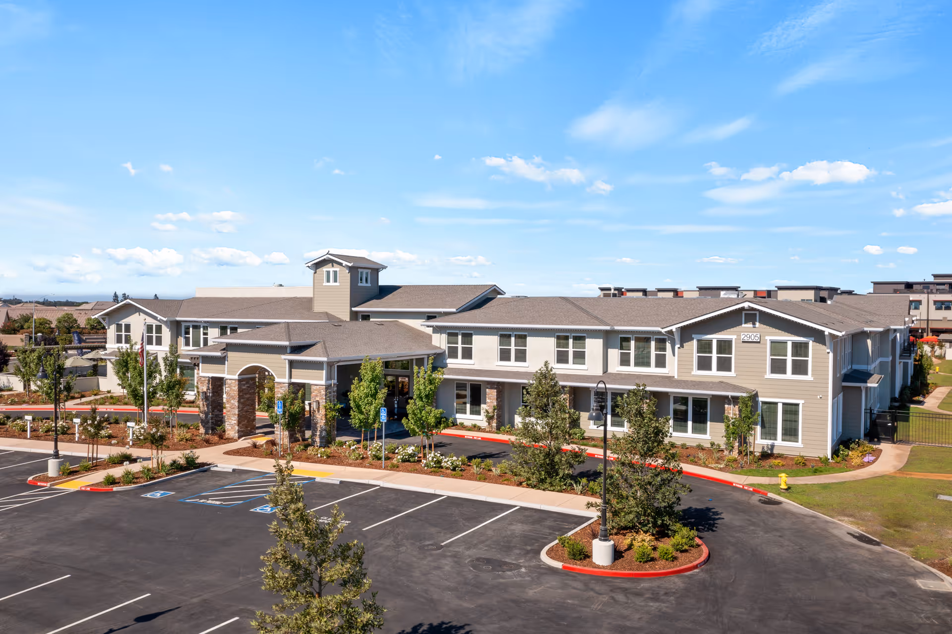 Exterior front view of the Oakmont of Lodi senior living building with landscaped grounds and an empty parking lot.