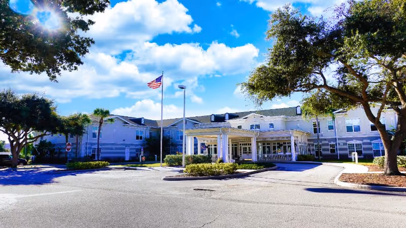 Exterior view of Sodalis Merritt Island facility with entrance, trees, and parking area.