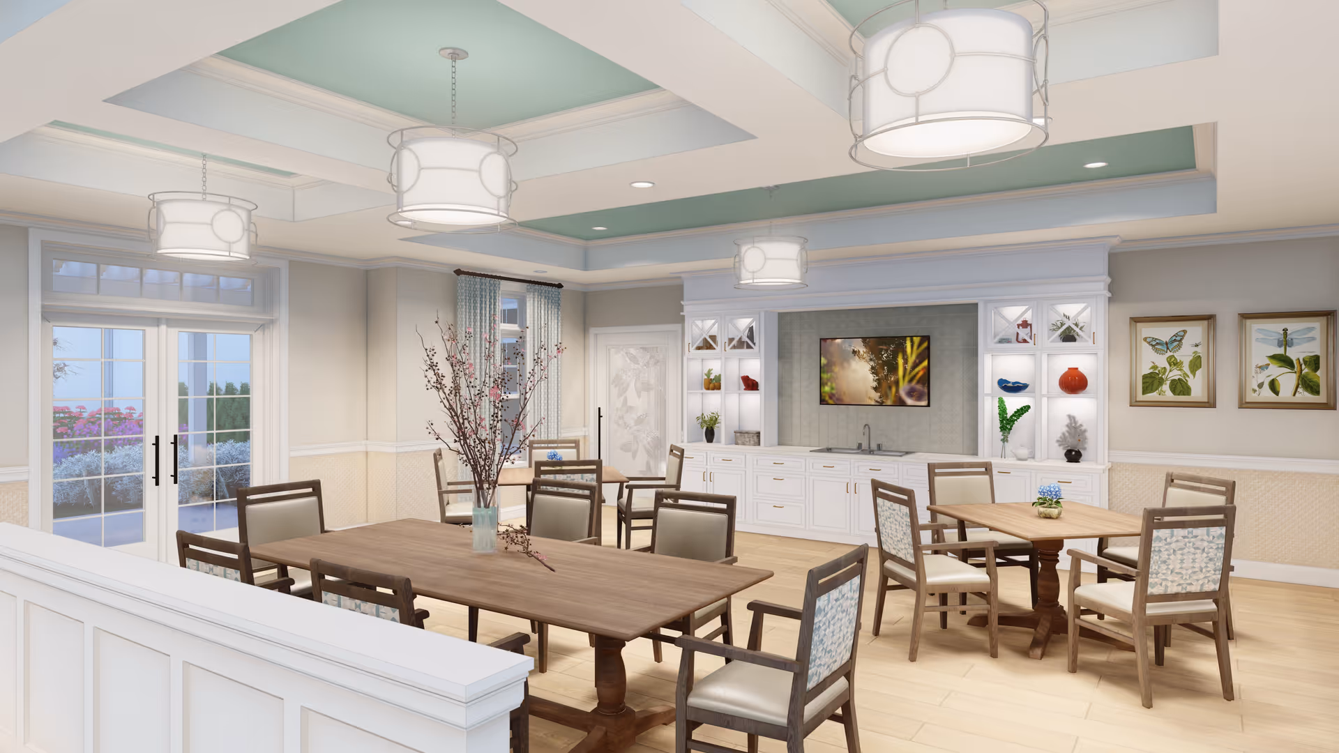 Bright communal dining room with wooden tables and chairs, built-in cabinetry and a TV, and pendant lights.