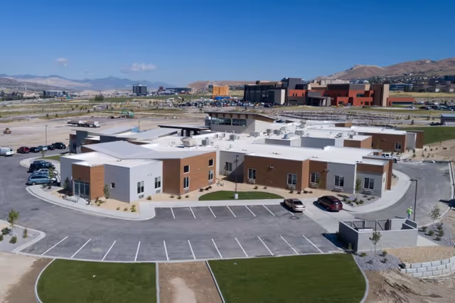 Aerial view of a single-story senior living facility building with a surrounding parking lot and landscaped grounds.