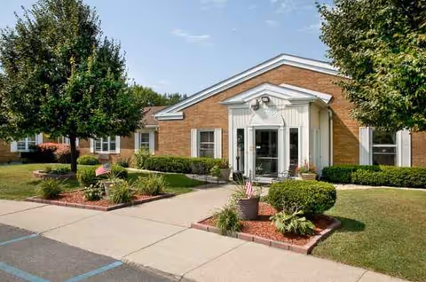 Exterior view of Hammond-Whiting Care Center with brick facade, front entrance, and landscaped shrubs.