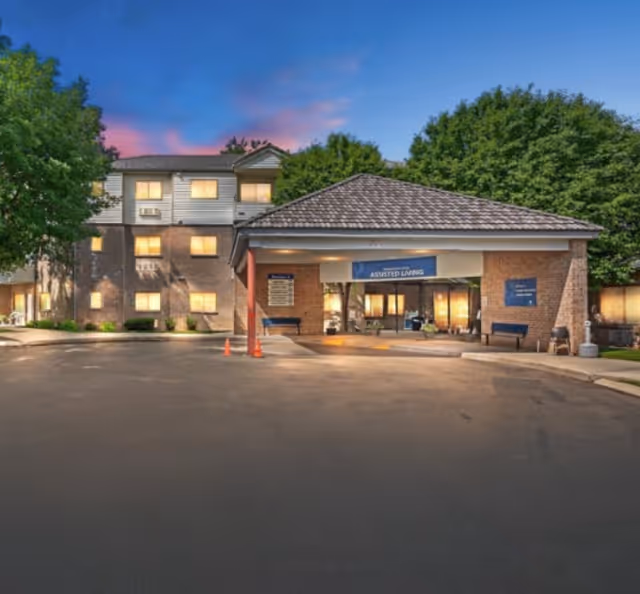A senior living facility entrance with an assisted living sign and brick exterior.