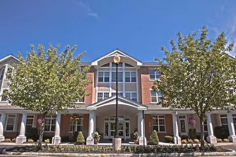 Exterior front view of Brandywine the Sycamore by Monarch senior living facility with trees