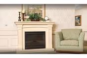 A cozy living area with a decorative fireplace mantel topped with candles and greenery and a green upholstered armchair to the right.