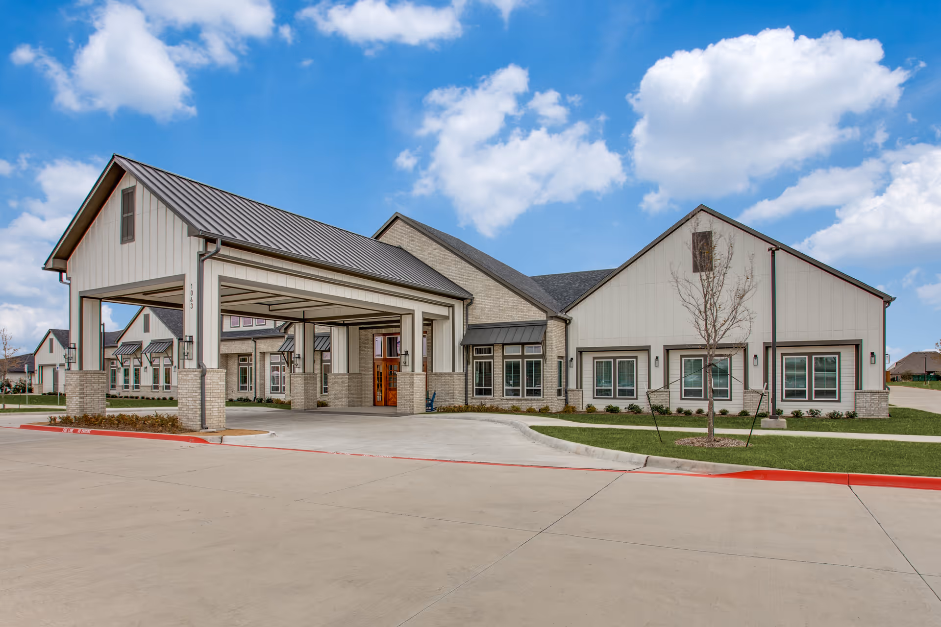 The Harvest of Aledo exterior: covered entrance, brick and siding, landscaped lawn.