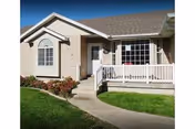 Front exterior view of a Canterbury Assisted Living EAST building with porch and lawn.