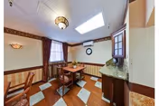 Small dining area with a square wooden table and chairs, skylight, patterned floor tiles and a countertop with cabinets.