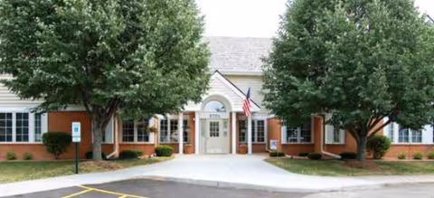 Front exterior of Brookdale Middleton Stonefield with trees and entrance.