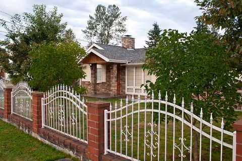 Exterior of Lucia's Adult Family Home with brick front and white decorative fence.
