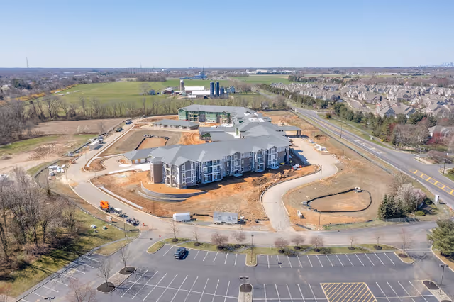 Aerial view of Parkers Bend Retirement Community buildings under construction surrounded by parking lots, roads, and open fields.