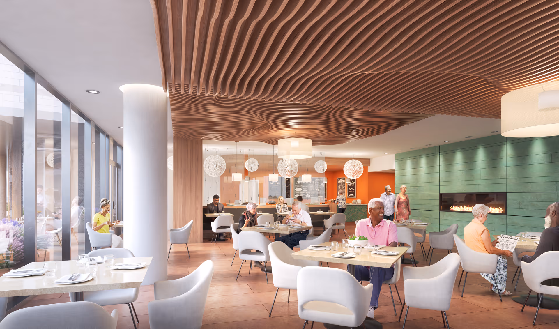 A modern dining room with several elderly people seated at tables enjoying meals and conversation. The room features large floor-to-ceiling windows on the left, a green wall with a built-in fireplace on the right, and a wooden slatted ceiling design. Pendant lights hang over the tables, and the atmosphere is bright and welcoming.