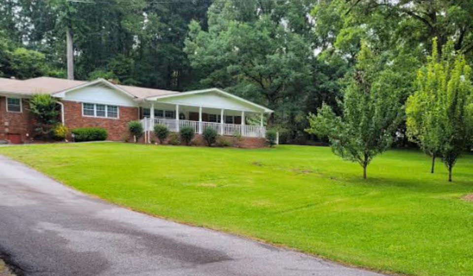 Front exterior of Angels Personal Care Home, a single-story brick building with a covered porch.
