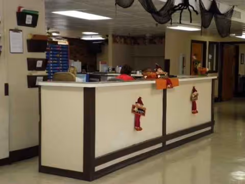 Interior reception area at Care Center of Dequincy with a long white front desk.