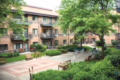 Outdoor courtyard of Siena on Brendenwood with trees, benches, and patio seating.