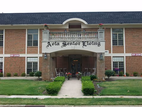 Front of Ava Senior Living facility with archway entrance and planters.