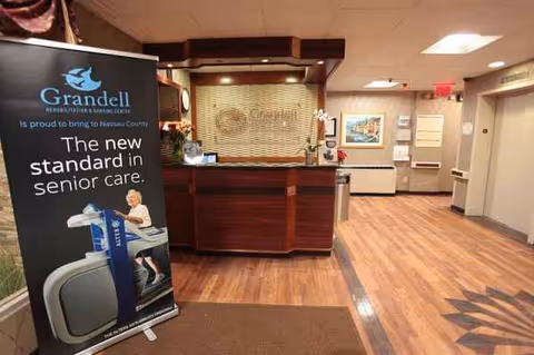 Reception area inside Grandell Rehabilitation and Nursing Center with a wooden front desk and banner.