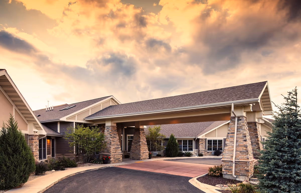 Exterior view of Mission Creek Senior Living with a covered entrance and stone pillars.