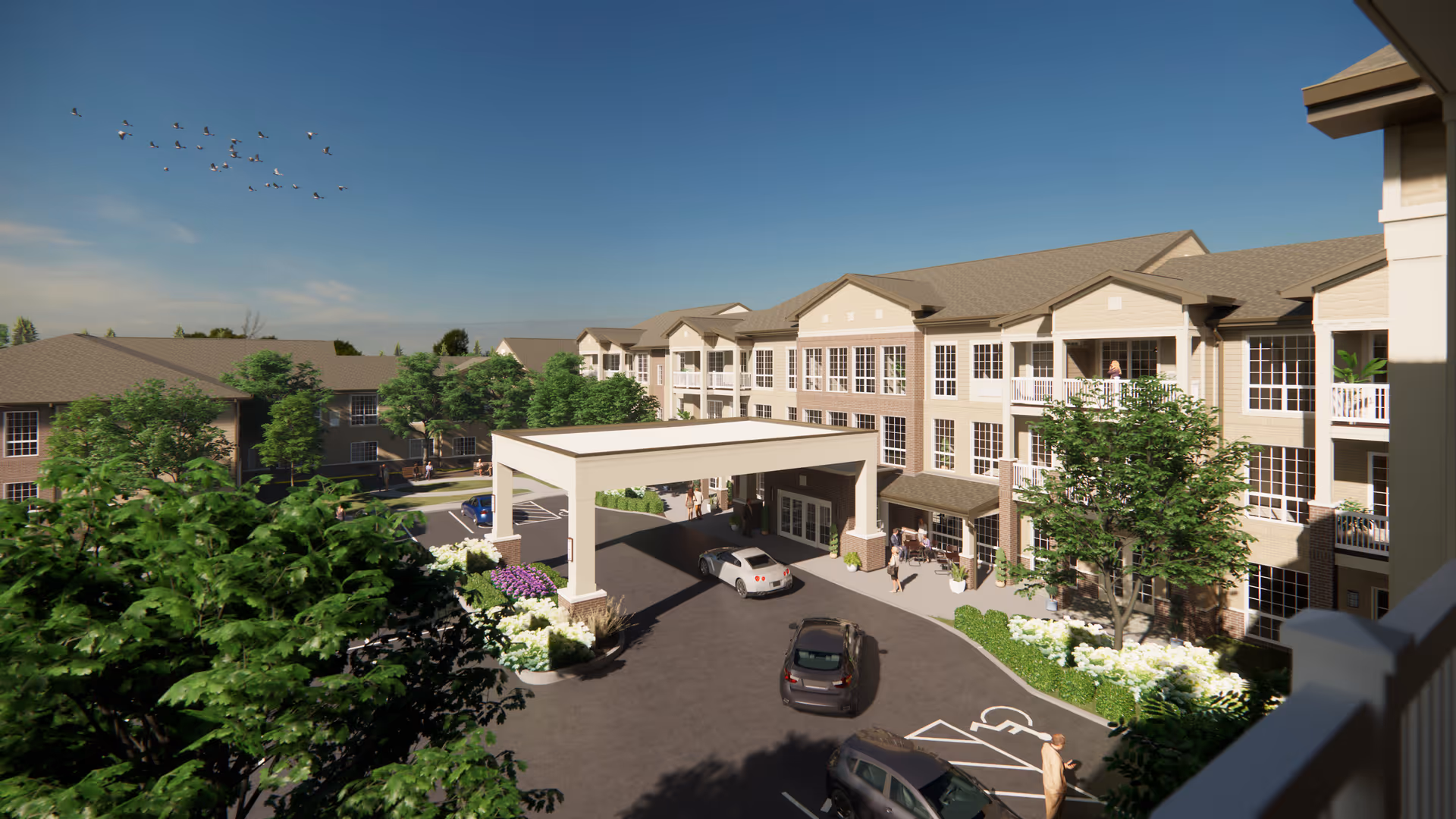 Three-story senior living building front with a covered drop-off (porte-cochère), parked cars, balconies, and landscaped grounds.
