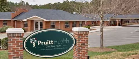 A brick facility exterior with a green PruittHealth Carolina Point sign at the front.