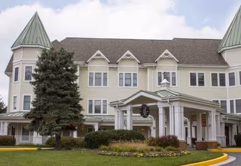 Sunrise of Pikesville exterior: cream building with a covered entrance and manicured lawn.