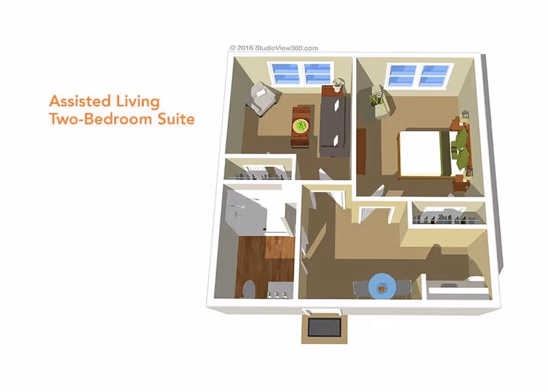 3D floor plan of an assisted living two-bedroom suite showing a living room with a sofa and chair, a bedroom with a bed and nightstands, a bathroom with a shower and toilet, and a dining area with a table and chairs.