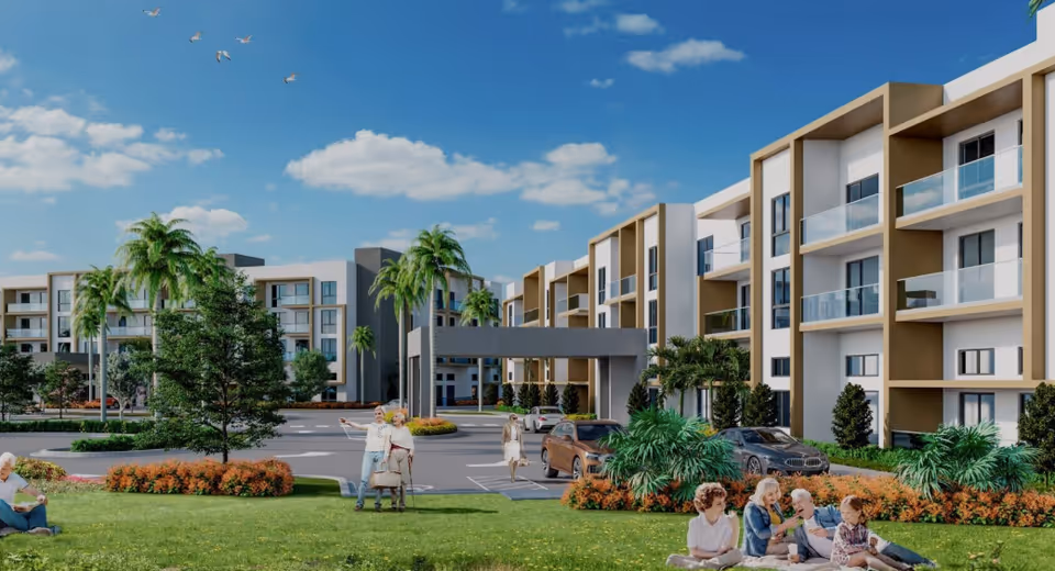 Modern multi-story senior living building with balconies, palm trees, cars in front, and people relaxing on the lawn under a blue sky.