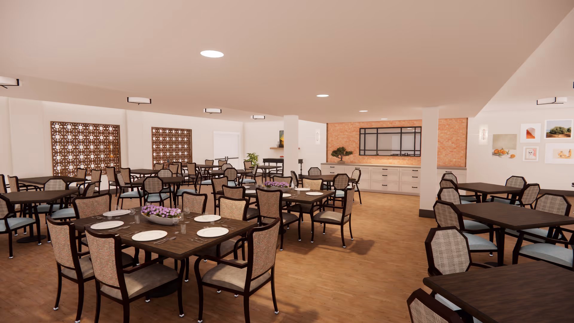 A spacious dining room with multiple dark wood tables and cushioned chairs arranged neatly. Some tables have white plates and glasses set on them, along with a centerpiece of purple flowers. The room has wooden flooring, white walls, decorative wall panels, framed artwork, and a sideboard with a brick accent wall behind it. The ceiling has recessed lighting.