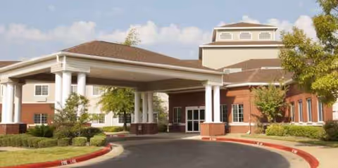 Senior living facility entrance with a covered porte-cochère and brick facade.